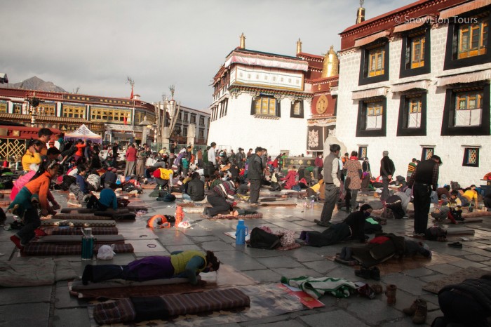 тибетские паломники выполняют простирания перед входов в Джокханг