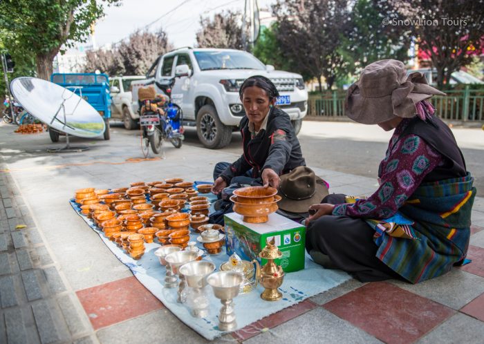 Торговец тибетских пиал и светильников на улице города Шигатце