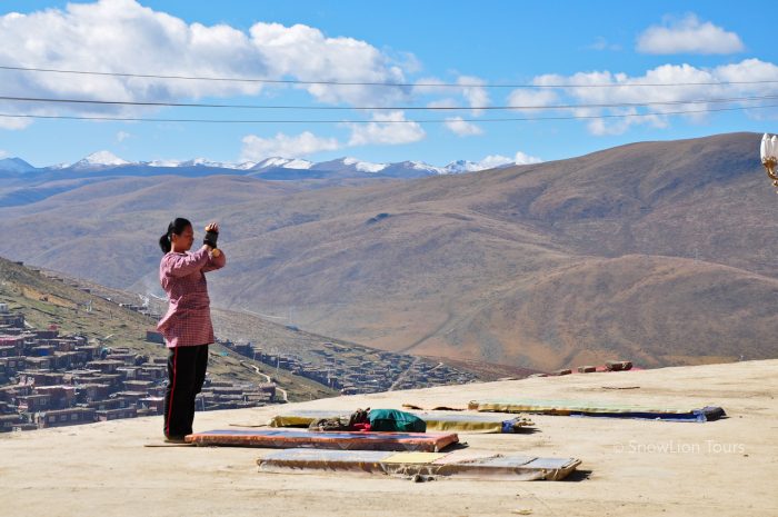 Тибетский паломник делает простирания, Ларунг Гар, кора вокруг монастыря, Серта Ларунг Гар, Восточный Тибет