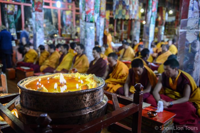 Масляная лампада и монахи на пудже, монастырь Дрикунг Тил, Лхаса, Тибет