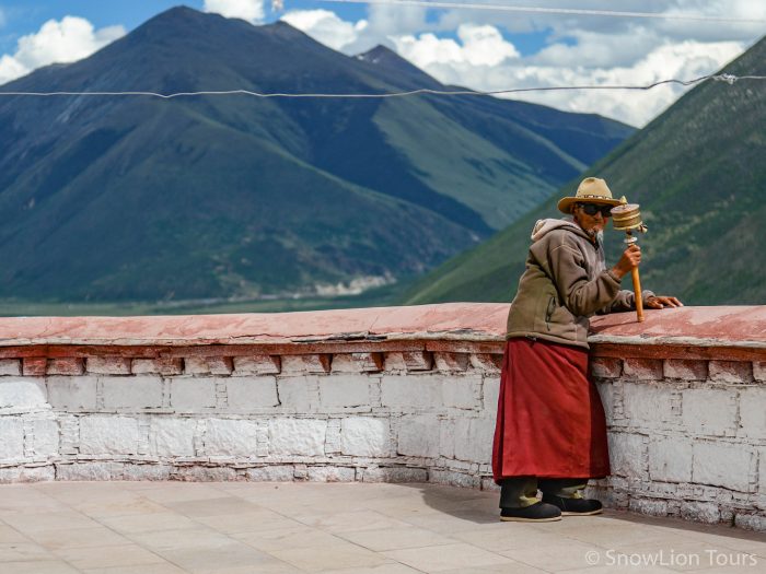 Монах крутит молитвенный барабан, монастырь Дрикунг Тил, Лхаса, Тибет, групповой тур в тибет